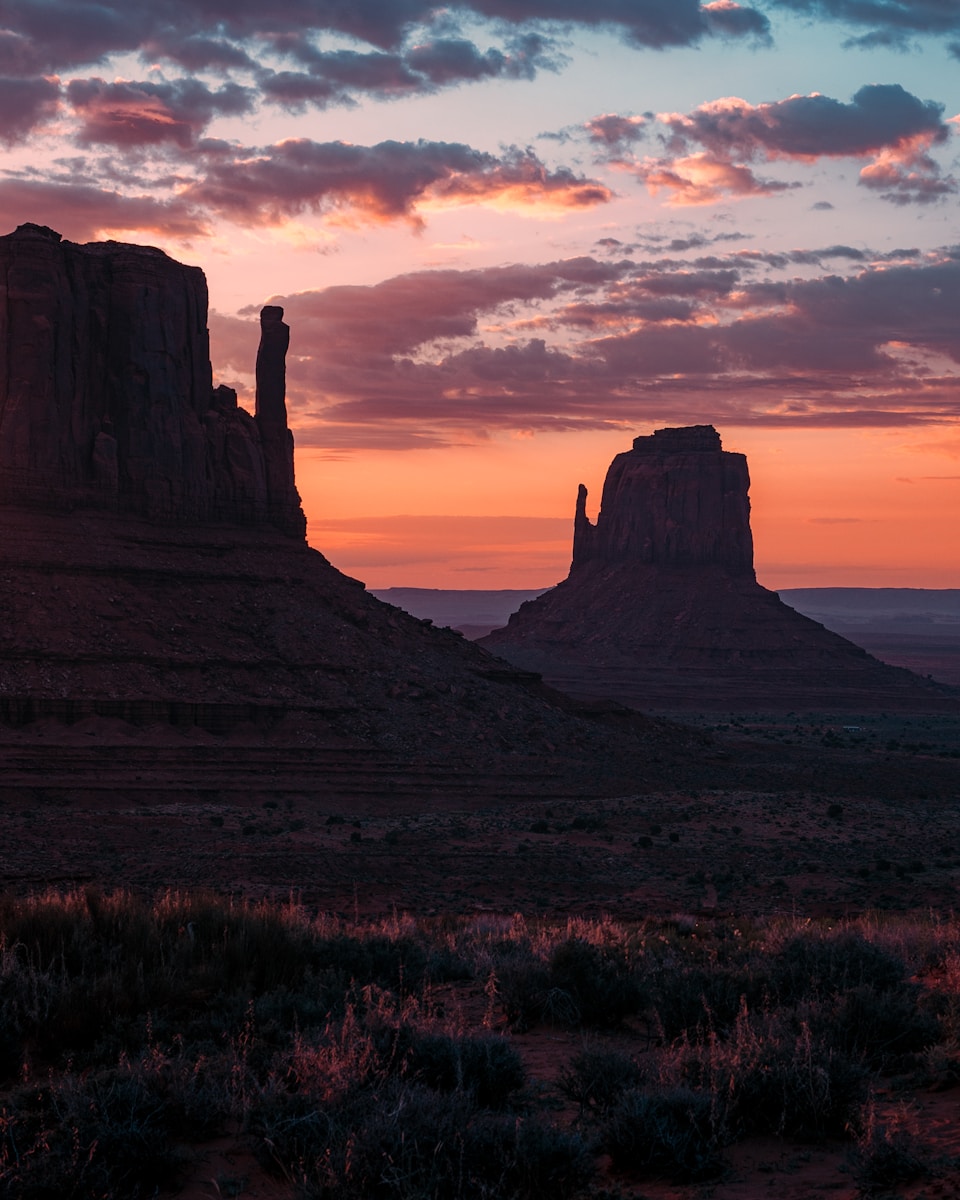 The sun is setting over the mountains in the desert